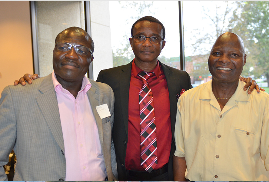 Three employees posing during a recognition event