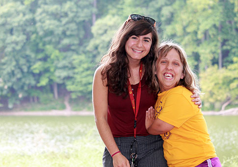 A child supported by CSS with her staff by the lake.